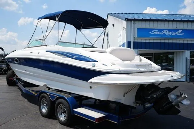 Slide: The Image of 2006 Crownline 252 EX boat on trailer, parked outside dealership under blue sky. - 5