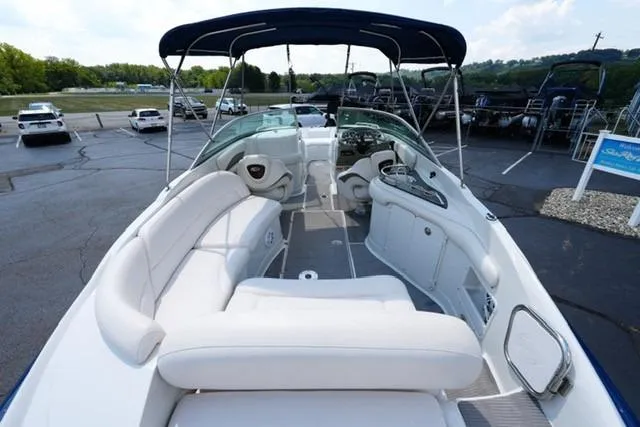 Slide: The Image of 2006 Crownline 252 EX boat with spacious seating and canopy in a parking lot. - 6