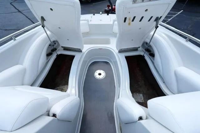 Slide: The Image of 2006 Crownline 252 EX boat interior with white seating and open storage compartments. - 8
