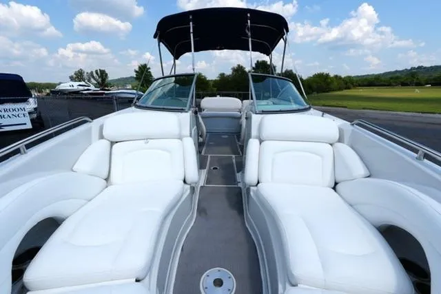 Slide: The Image of 2006 Crownline 252 EX boat with white seating and canopy, docked under a blue sky. - 9
