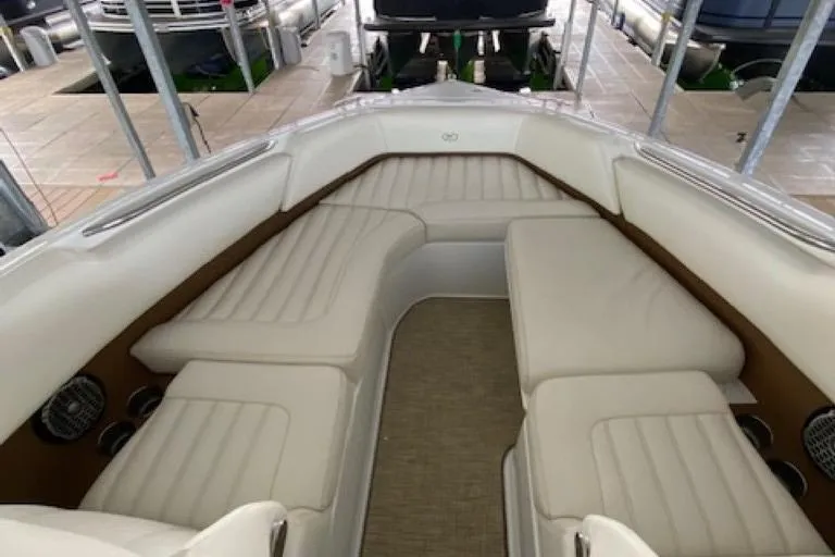 Slide: The Image of 2015 Cobalt R7 boat interior with white cushioned seating in a docked setting. - 10