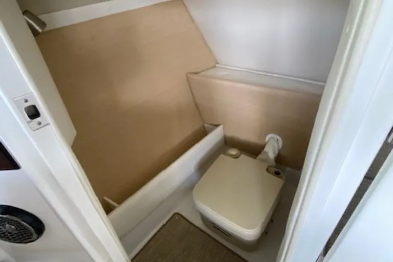 Slide: The Image of Compact bathroom in 2015 Cobalt R7 boat with beige interior and portable toilet. - 9