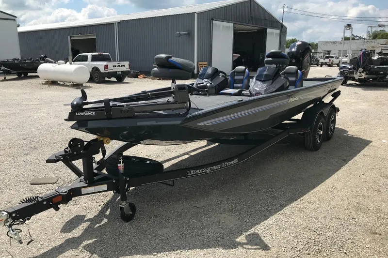 Slide: The Image of 2026 Ranger RT198P fishing boat on trailer, parked outside a large garage. - 3