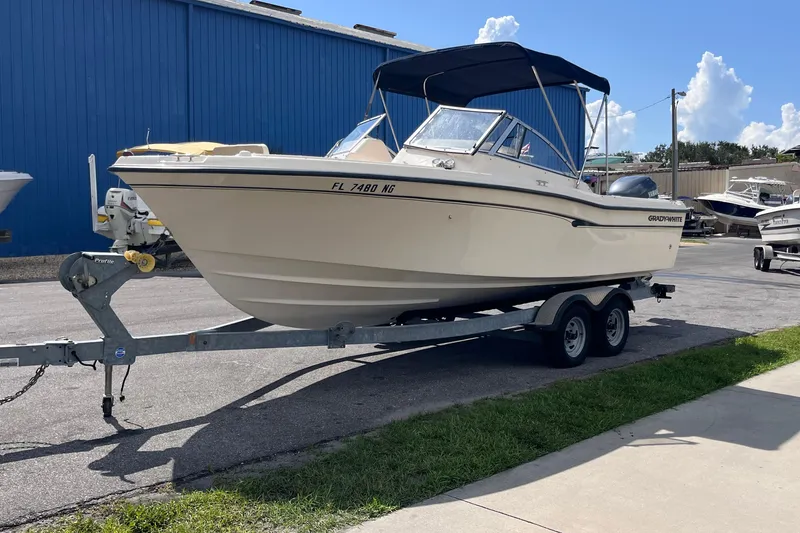 The Image of 2006 Grady-White Tournament 225 boat on trailer, parked near blue building. - 1