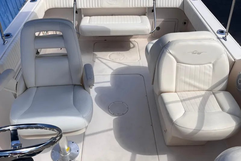 Slide: The Image of 2006 Grady-White Tournament 225 boat interior with white seating and steering wheel. - 11