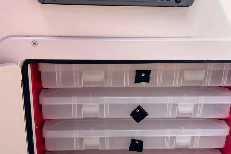 Slide: The Image of Storage compartment with clear tackle boxes on a 2006 Grady-White Tournament 225 boat. - 17