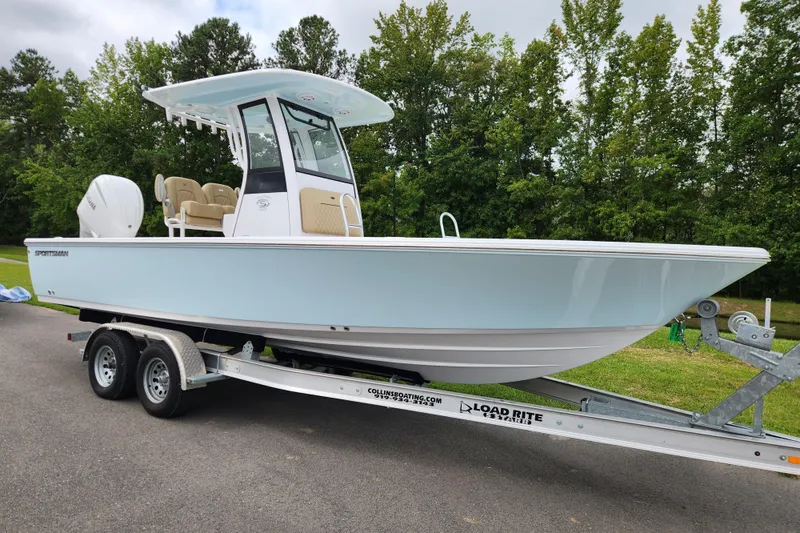 Slide: The Image of 2026 Sportsman Masters 247 Bay Boat on trailer, parked outdoors with trees in background. - 1