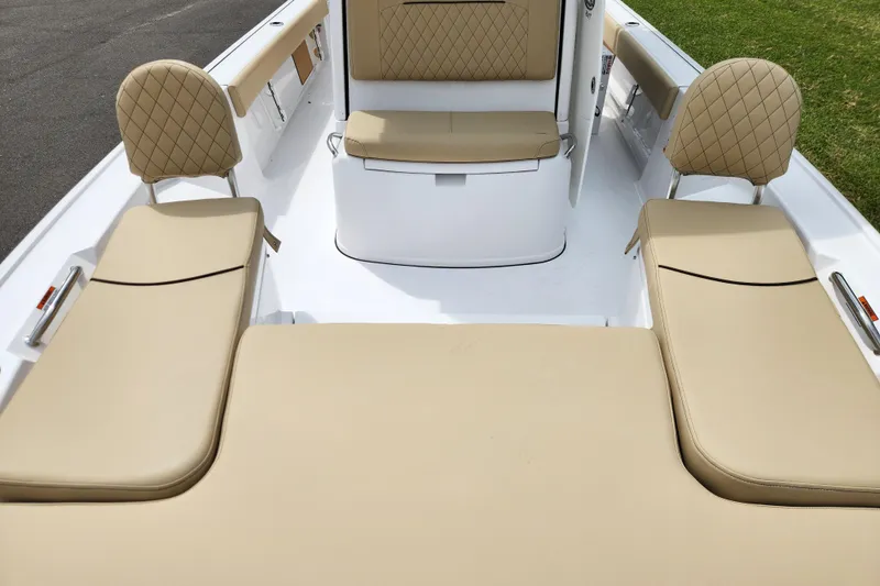 Slide: The Image of 2026 Sportsman Masters 247 Bay Boat interior with tan cushioned seating and diamond stitching. - 14