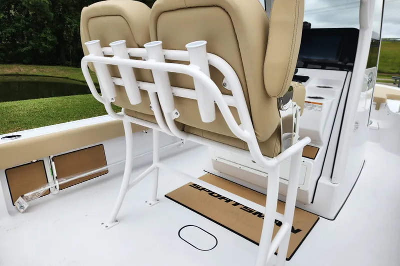 Slide: The Image of 2026 Sportsman Masters 247 Bay Boat interior with beige seating and rod holders. - 26