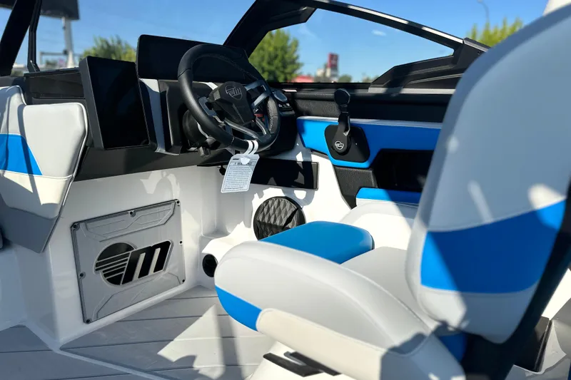 Slide: The Image of 2025 Malibu Wakesetter 23 LSV interior with modern steering and blue-accented seating. - 13