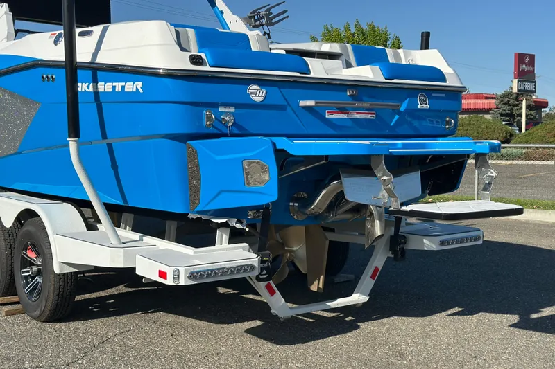 Slide: The Image of 2025 Malibu Wakesetter 23 LSV boat on trailer, rear view, vibrant blue color. - 3