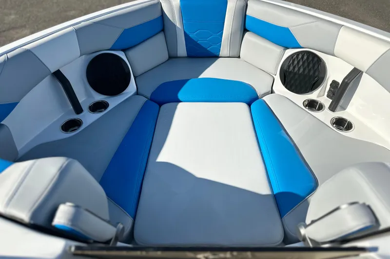 Slide: The Image of 2025 Malibu Wakesetter 23 LSV interior with blue and gray seating, cup holders, and speakers. - 6