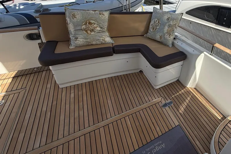 Slide: The Image of 2018 Beneteau Swift Trawler 44 interior with cushioned seating and wooden flooring. - 10