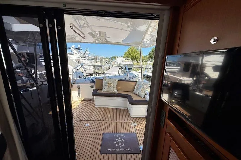 Slide: The Image of 2018 Beneteau Swift Trawler 44 interior with outdoor seating and marina view. - 11