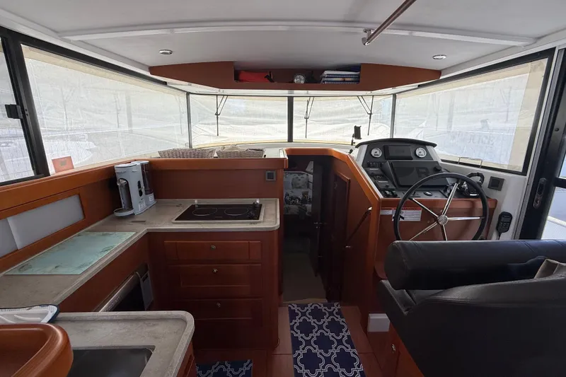 Slide: The Image of 2018 Beneteau Swift Trawler 44 interior with helm, kitchen, and modern amenities. - 12