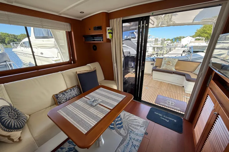 Slide: The Image of Interior of 2018 Beneteau Swift Trawler 44, featuring cozy seating and elegant wood finishes. - 13