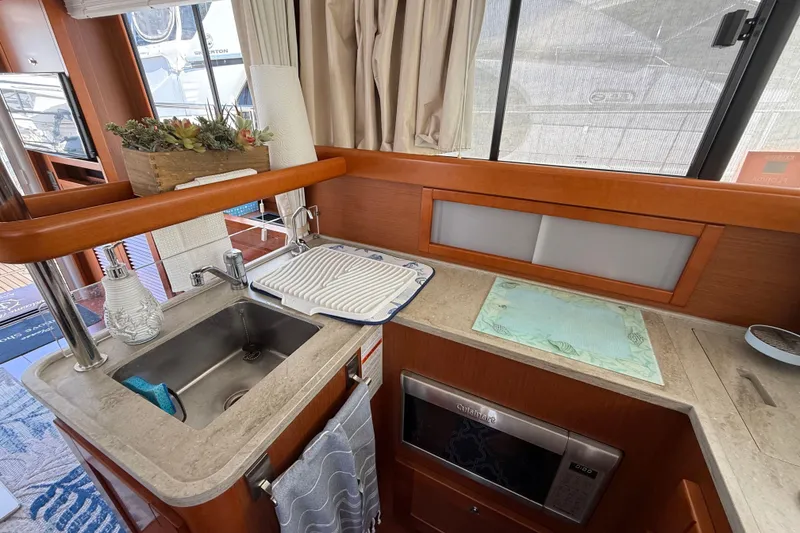 Slide: The Image of 2018 Beneteau Swift Trawler 44 kitchen with sink, microwave, and countertop decor. - 15