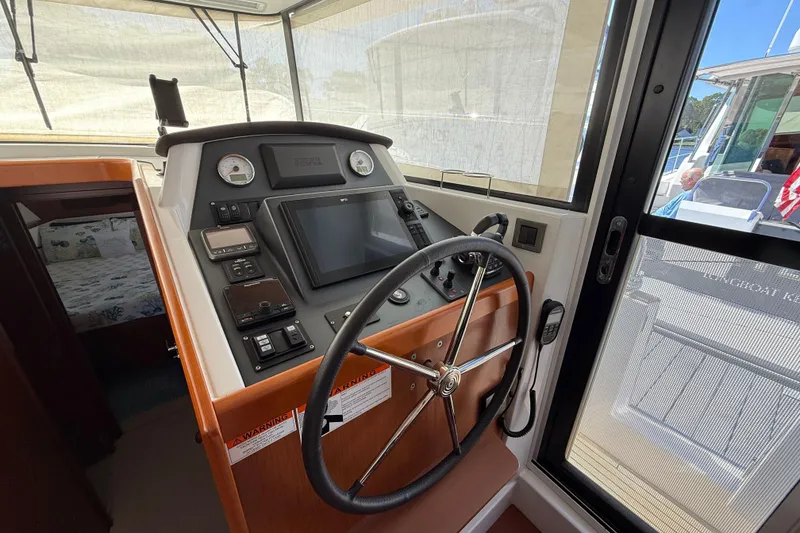 Slide: The Image of 2018 Beneteau Swift Trawler 44 helm with navigation controls and steering wheel. - 16