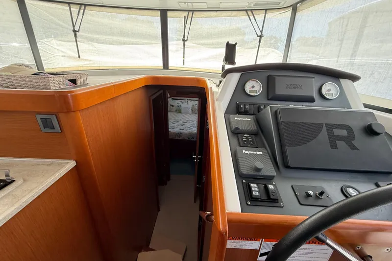 Slide: The Image of 2018 Beneteau Swift Trawler 44 helm with navigation controls and cabin view. - 20
