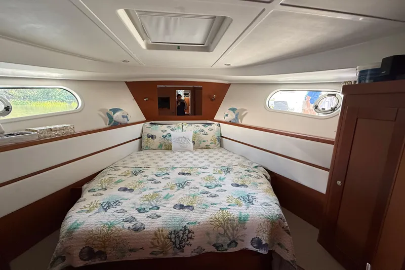 Slide: The Image of Cozy bedroom in 2018 Beneteau Swift Trawler 44 with nautical-themed decor. - 21