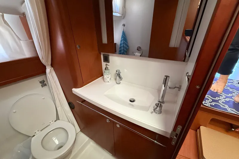 Slide: The Image of 2018 Beneteau Swift Trawler 44 bathroom with sink, toilet, and wooden cabinetry. - 24