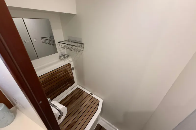 Slide: The Image of Bathroom interior of 2018 Beneteau Swift Trawler 44 with wooden accents and storage shelves. - 27