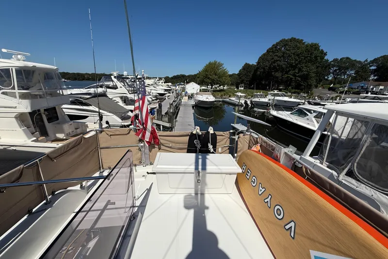 Slide: The Image of 2018 Beneteau Swift Trawler 44 docked at marina, surrounded by boats, clear sky. - 33
