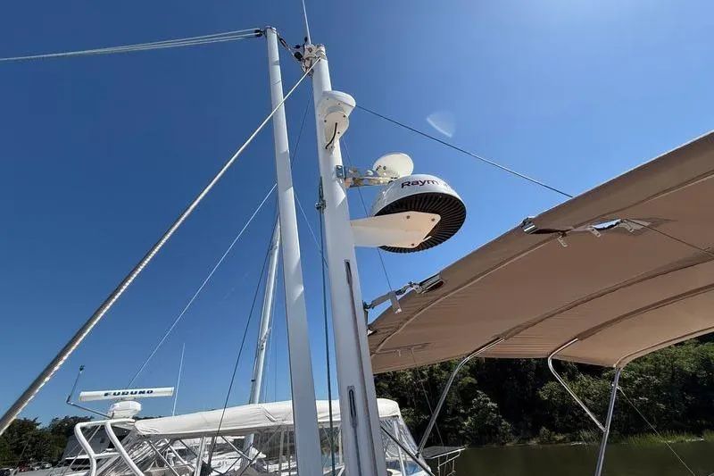 Slide: The Image of 2018 Beneteau Swift Trawler 44 with radar equipment and canopy under clear blue sky. - 34