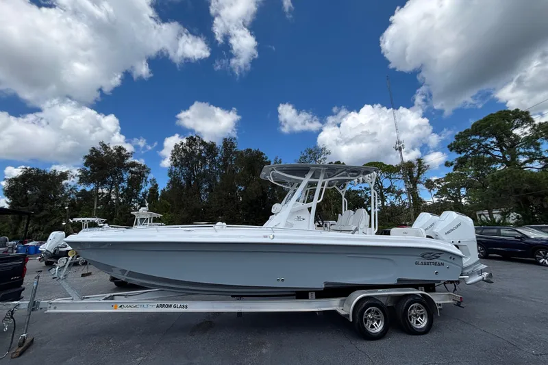 The Image of 2026 Glasstream 280 Pro-XS boat on trailer under blue sky with clouds. - 0