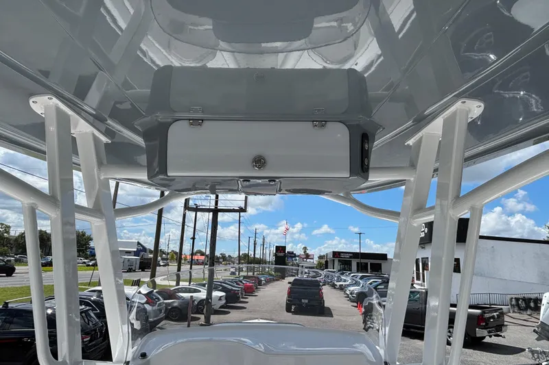 Slide: The Image of 2026 Glasstream 280 Pro-XS boat interior view with overhead storage and dealership background. - 21