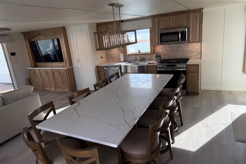 Slide: The Image of Luxurious Sumerset 2025 houseboat interior with modern kitchen, marble dining table, and large TV. - 34