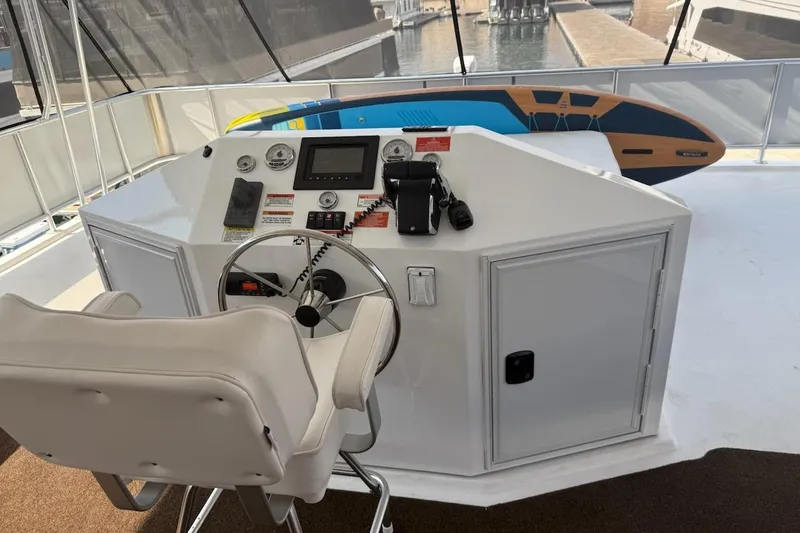 Slide: The Image of Helm of 2025 Sumerset Relentless Multiple Shares houseboat with steering wheel and control panel. - 5