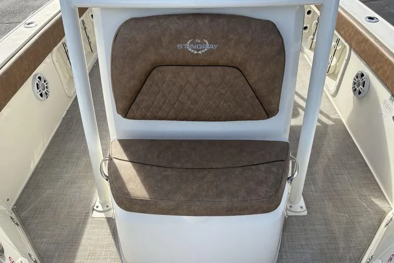 Slide: The Image of 2021 Stingray 236CC boat seat with brown cushioned upholstery and white frame. - 12