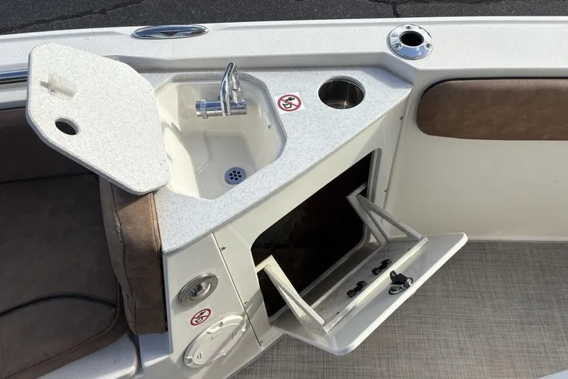 Slide: The Image of 2021 Stingray 236CC boat interior with sink, storage, and seating area. - 13