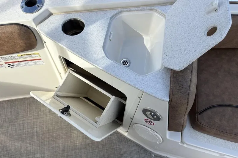 Slide: The Image of 2021 Stingray 236CC boat interior with sink, storage, and cup holder. - 14