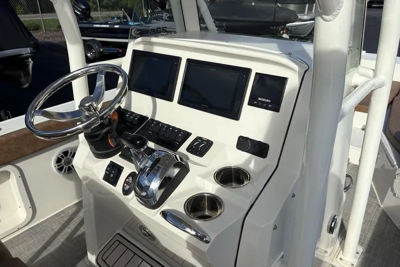 Slide: The Image of 2021 Stingray 236CC boat dashboard with steering wheel, dual screens, and control panel. - 15