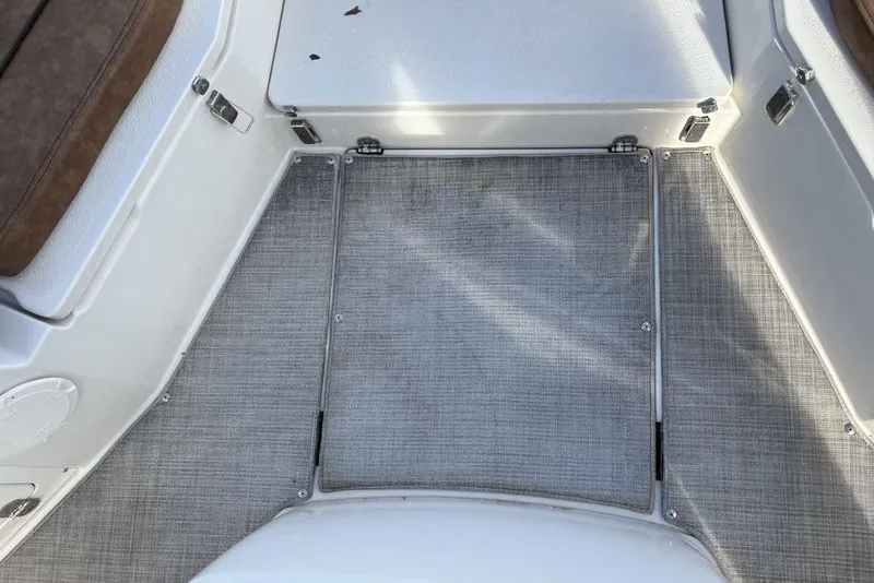 Slide: The Image of 2021 Stingray 236CC boat interior with gray flooring and brown seating. - 16