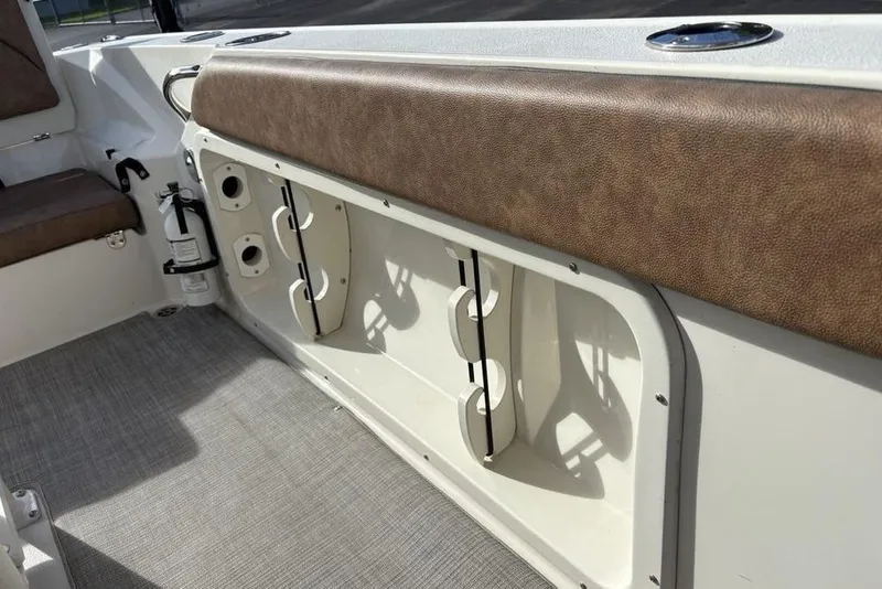 Slide: The Image of 2021 Stingray 236CC boat interior with brown seating and storage compartments. - 17