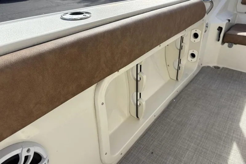 Slide: The Image of 2021 Stingray 236CC boat interior with brown upholstery and storage compartments. - 18