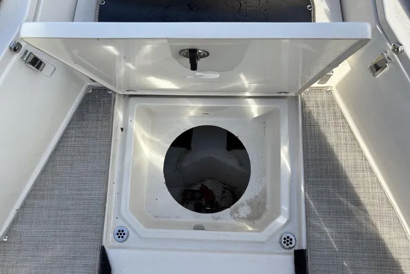 Slide: The Image of Open storage compartment on a 2021 Stingray 236CC boat, featuring a circular opening. - 19