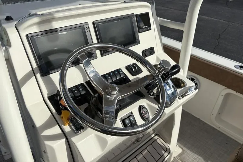 Slide: The Image of 2021 Stingray 236CC boat dashboard with steering wheel and dual display screens. - 21