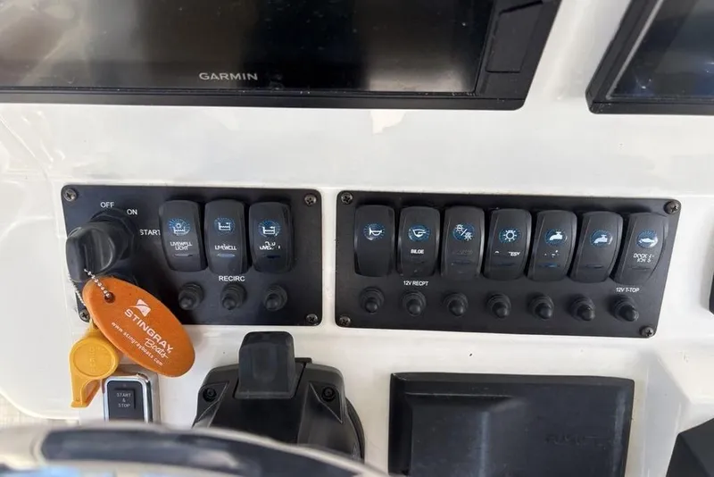 Slide: The Image of Control panel of a 2021 Stingray 236CC boat with labeled switches and key fob. - 24