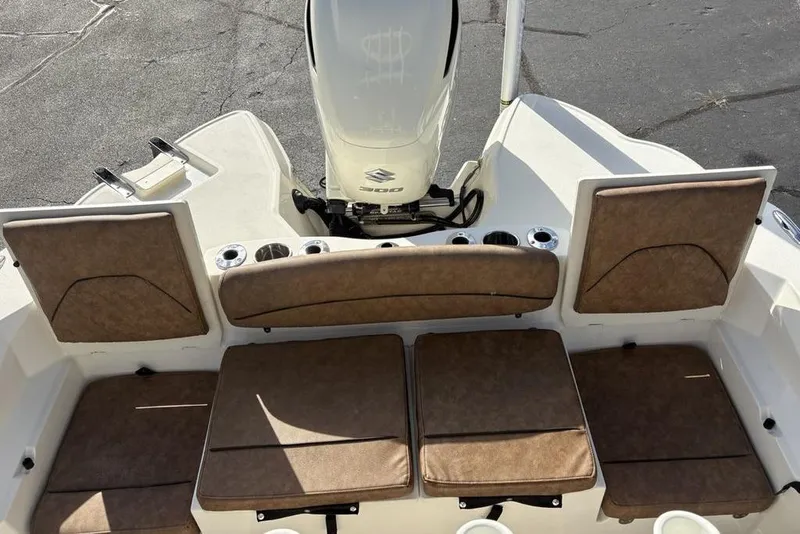 Slide: The Image of 2021 Stingray 236CC boat interior with brown cushioned seating and Suzuki outboard motor. - 28