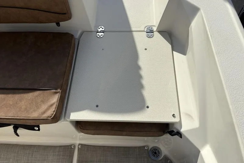 Slide: The Image of 2021 Stingray 236CC boat interior with brown seating and storage compartment. - 31