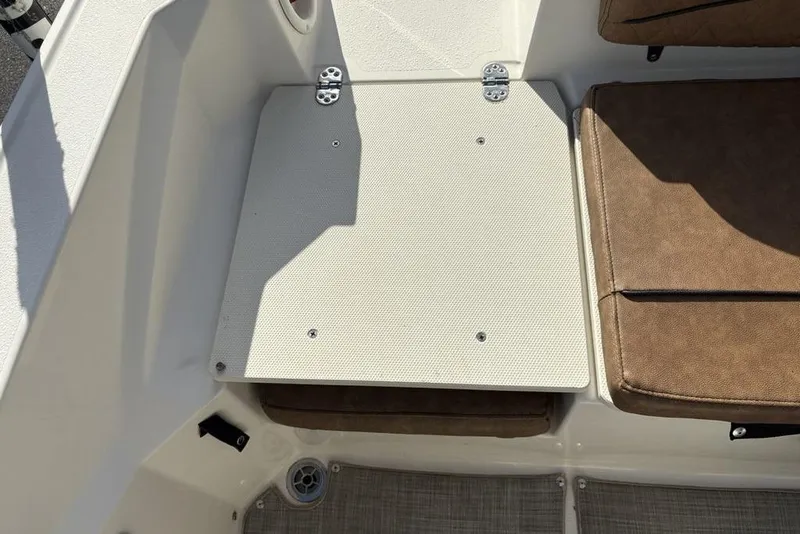Slide: The Image of 2021 Stingray 236CC boat interior with brown seating and storage compartment. - 32