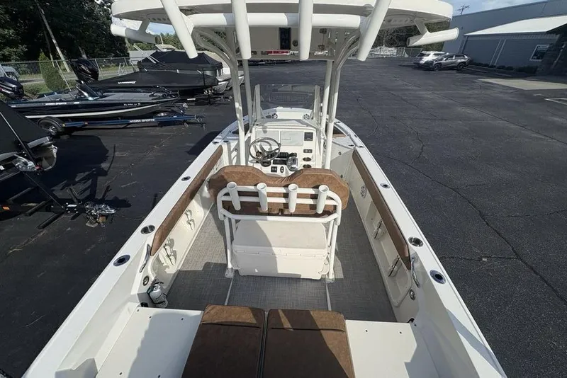 Slide: The Image of 2021 Stingray 236CC boat interior with helm, seating, and storage, parked outdoors. - 35