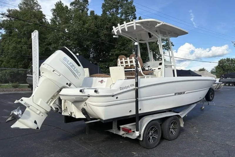 Slide: The Image of 2021 Stingray 236CC boat on trailer with Suzuki outboard motor, parked outdoors. - 9