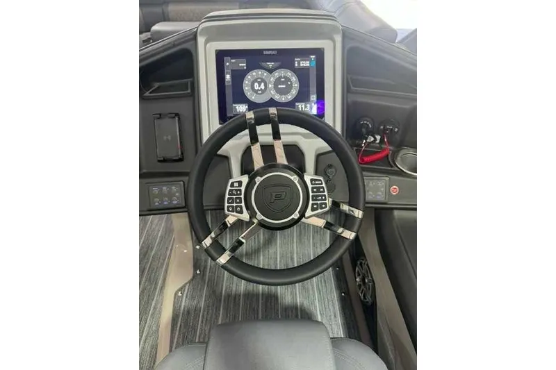 Slide: The Image of Steering wheel and dashboard of 2024 Premier 250 Intrigue RL boat, featuring modern controls and display. - 4