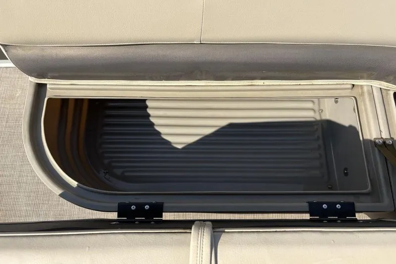 Slide: The Image of 2021 Sun Tracker Party Barge® 18 DLX storage compartment with open lid, showcasing interior space. - 12