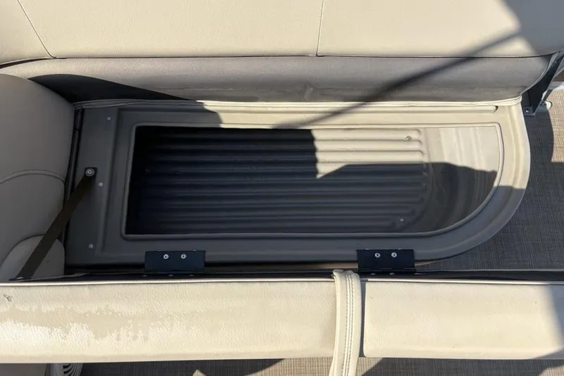 Slide: The Image of 2021 Sun Tracker Party Barge® 18 DLX storage compartment with open seat cushion. - 21